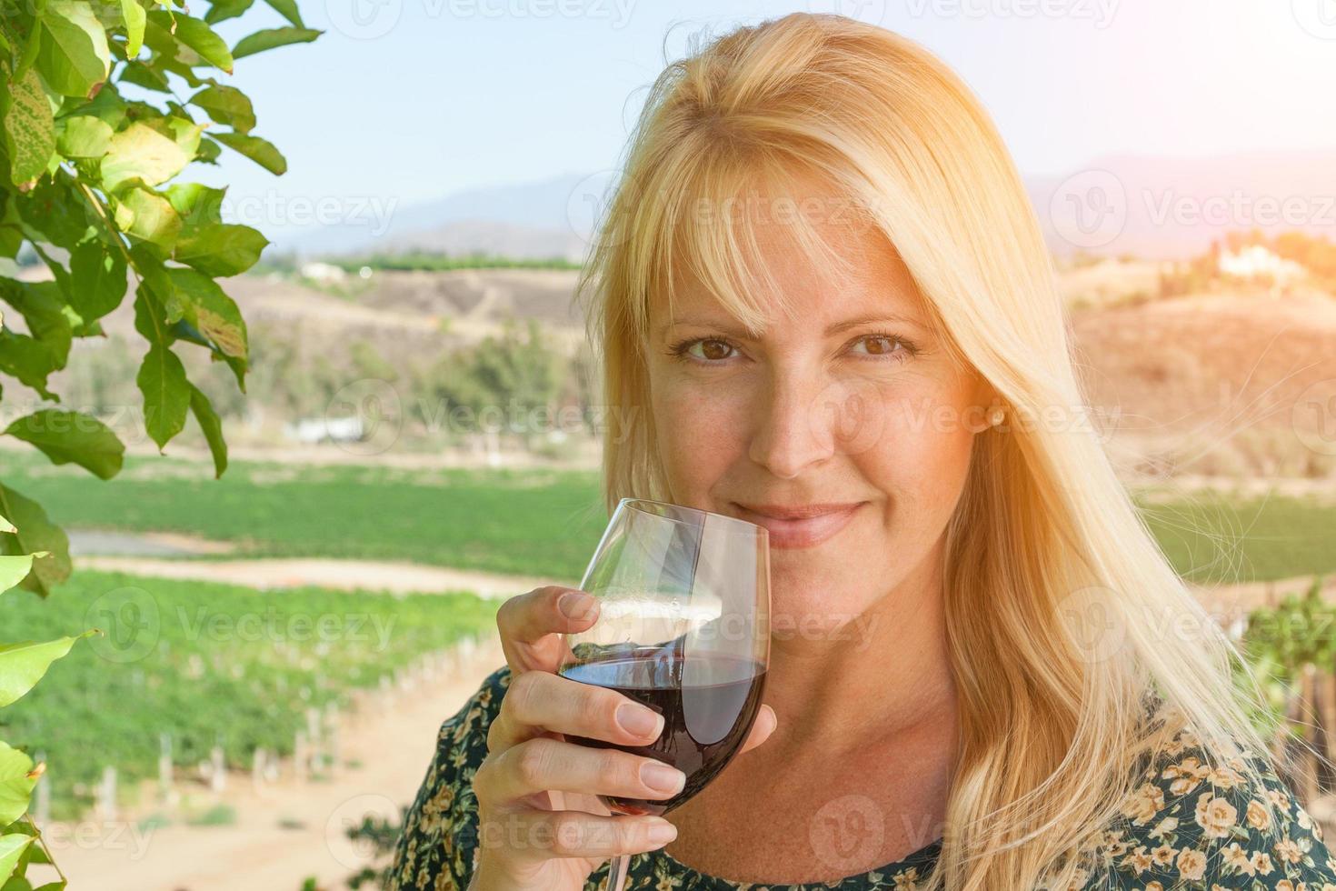 mooi jong volwassen vrouw genieten van glas van wijn proeverij in de wijngaard foto
