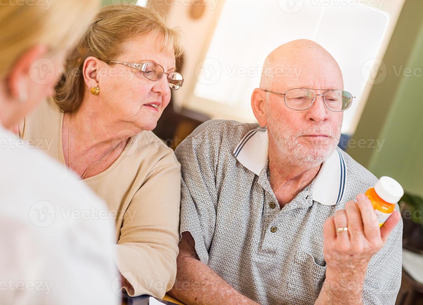 dokter of verpleegster uitleggen voorschrift geneeskunde naar senior volwassen paar foto