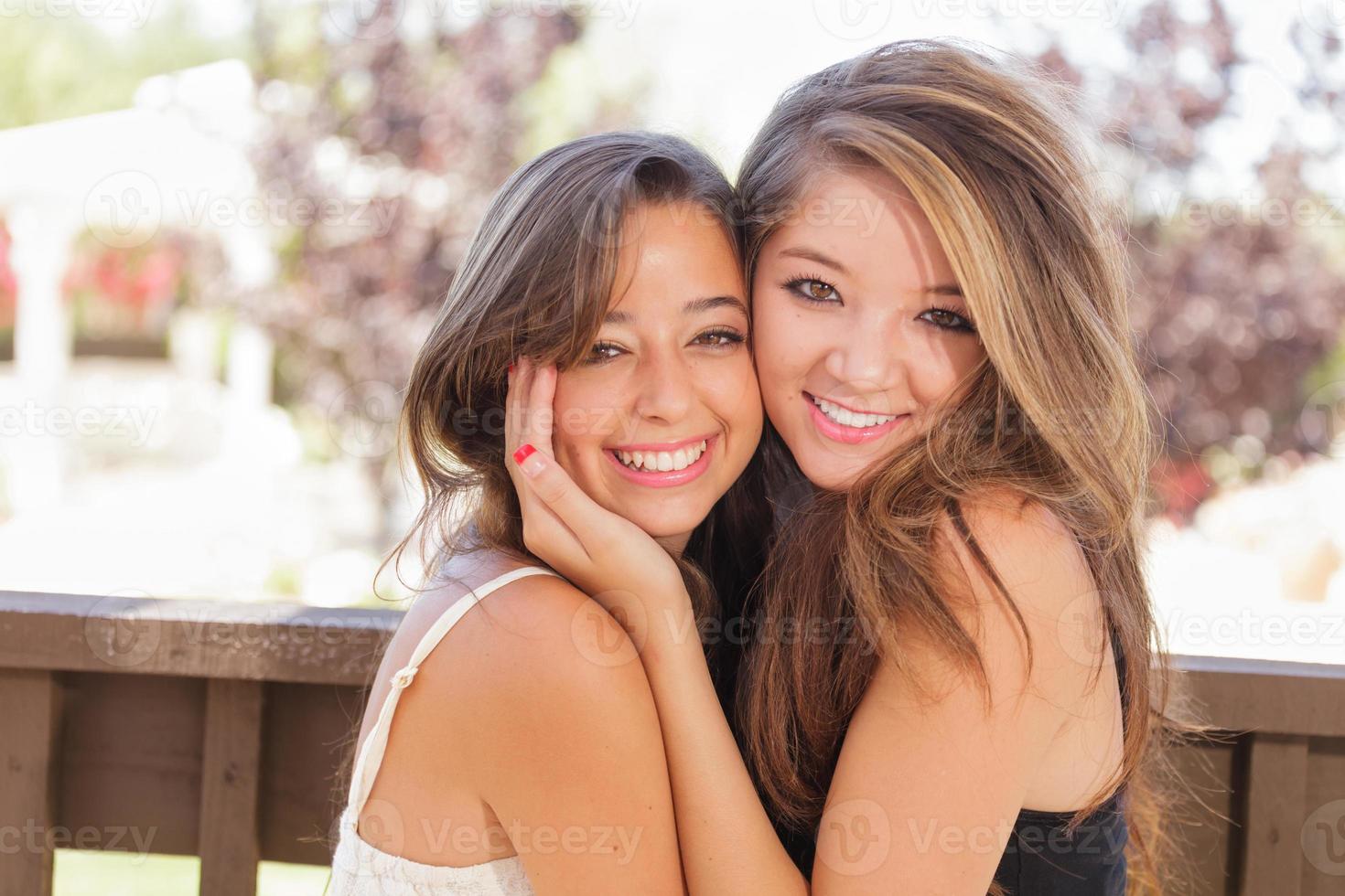 twee gemengd ras vriendinnetjes houding voor portret buitenshuis foto