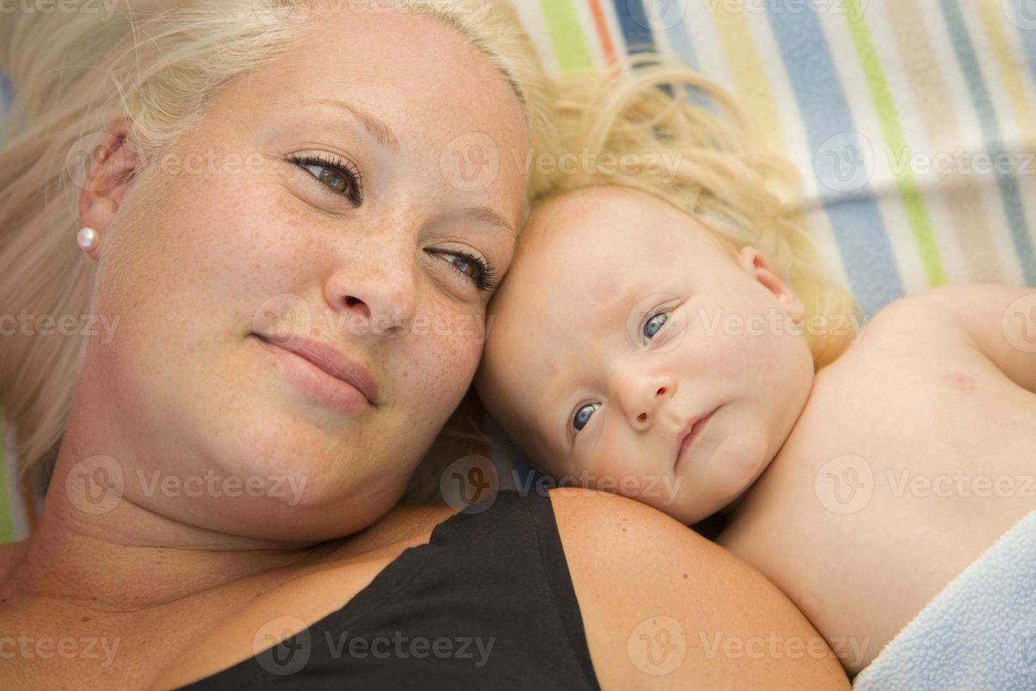 schattig baby jongen houdende De volgende naar zijn mama Aan deken foto