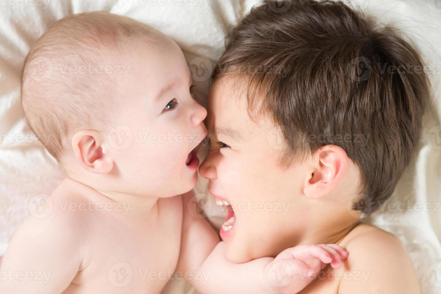 gemengd ras Chinese en Kaukasisch baby broers hebben pret houdende Aan hun deken foto