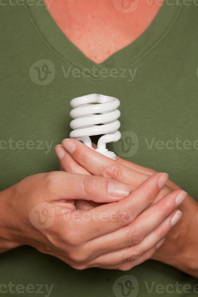 vrouw handen Holding energie besparing licht lamp foto