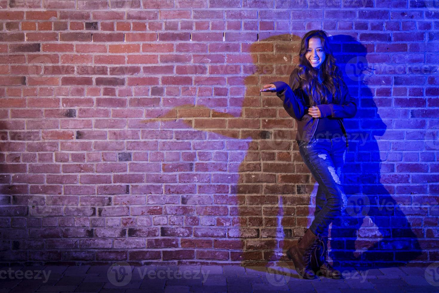 gemengd ras vrouw Holding haar hand- uit tegen steen muur foto