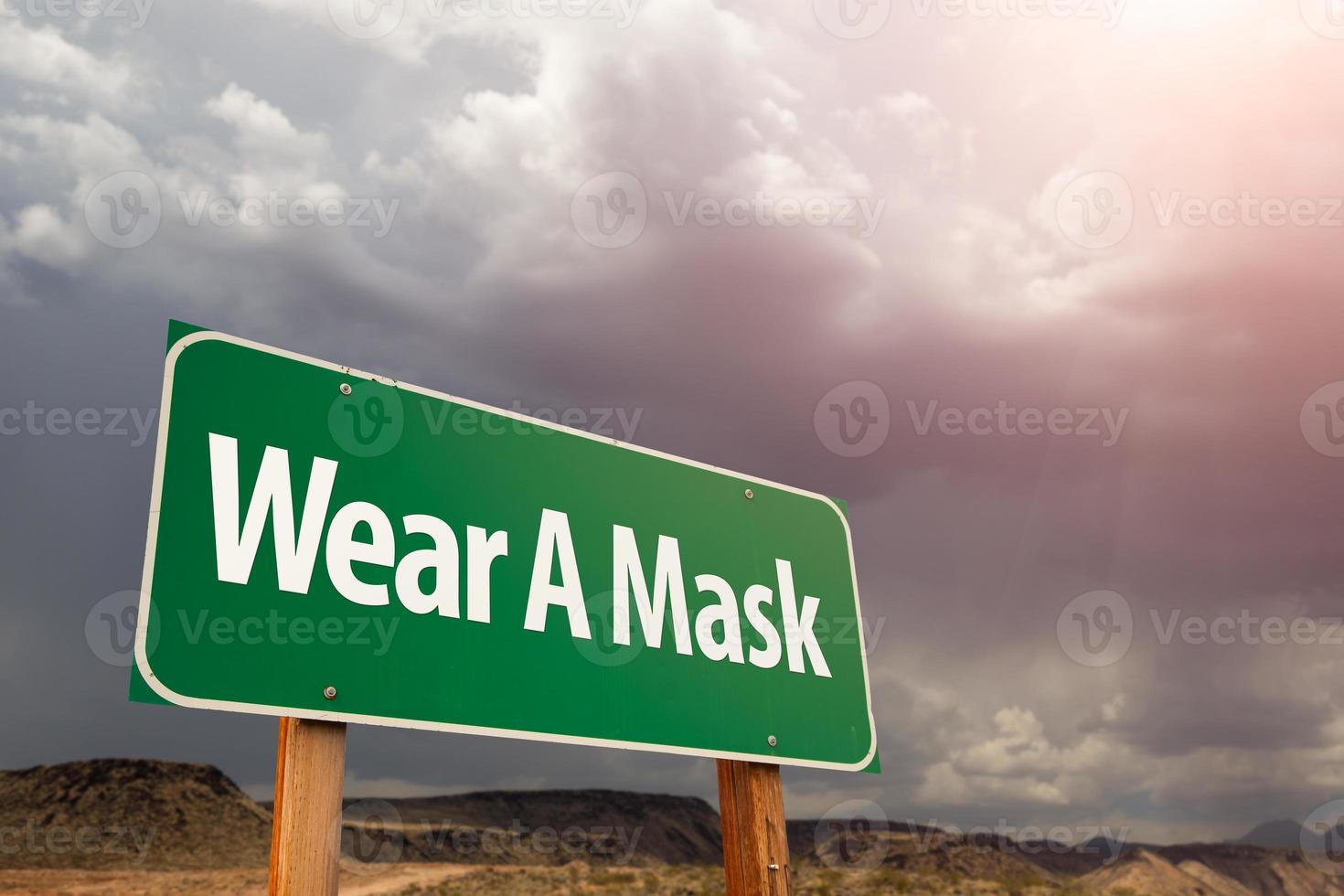 slijtage een masker groen weg teken tegen onheilspellend stormachtig bewolkt lucht foto