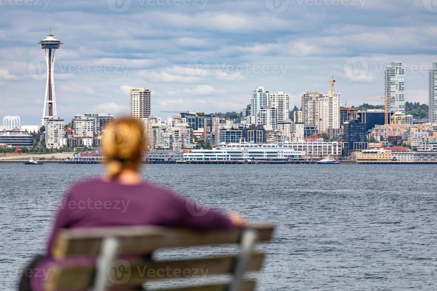 vrouw zittend Aan bank op zoek Bij de Seattle, Washington horizon foto