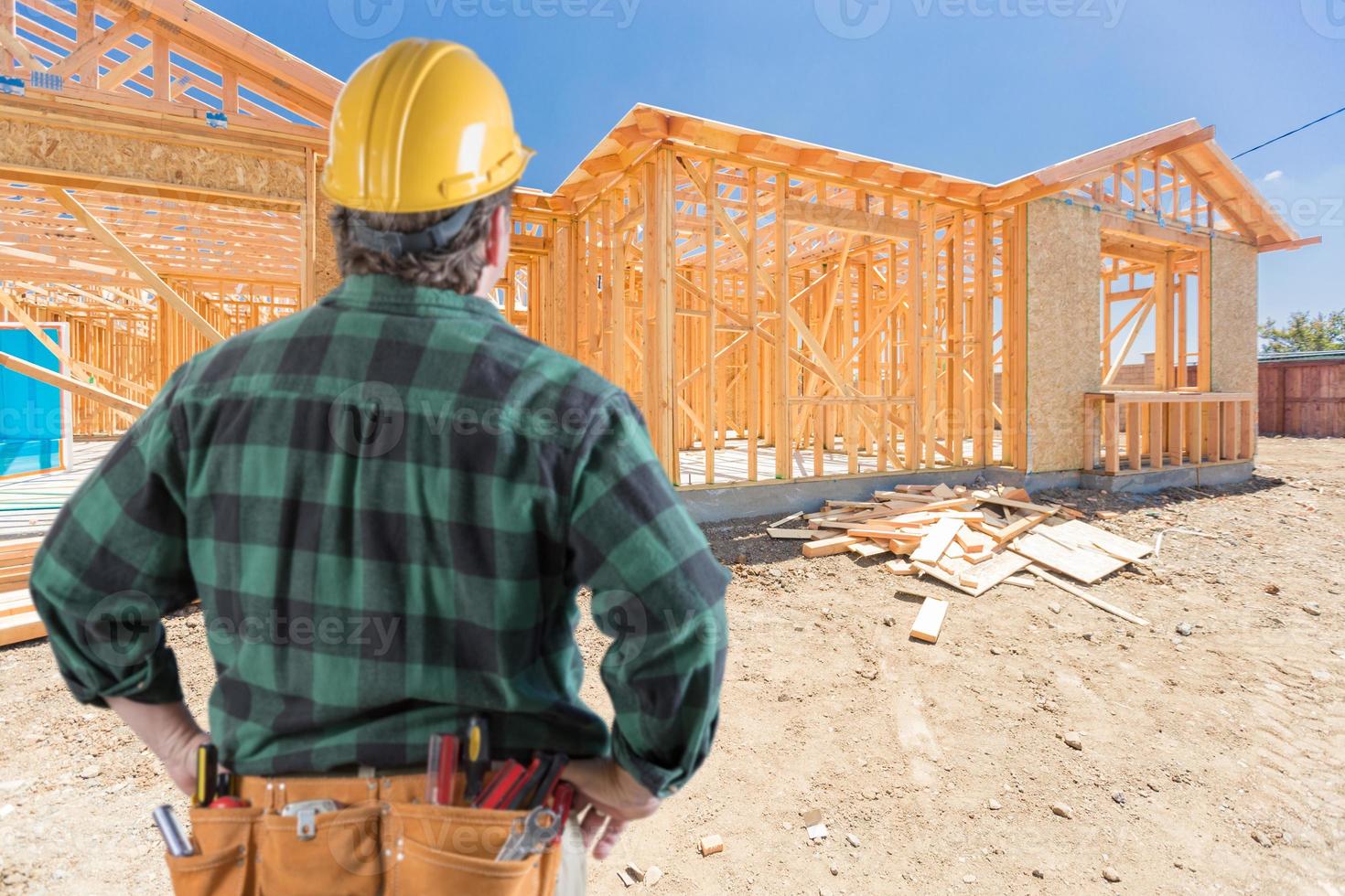 aannemer staand buiten bouw framing van nieuw huis. foto