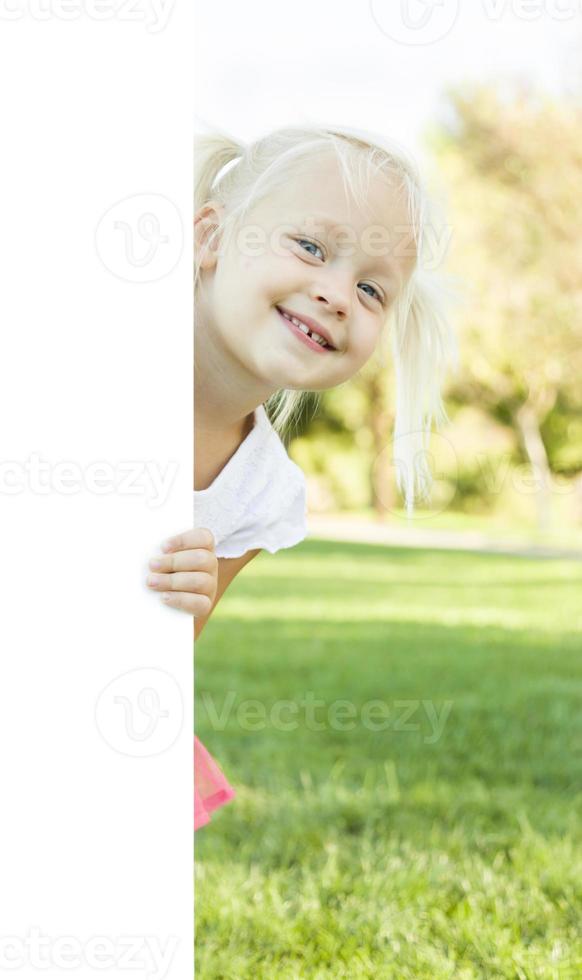 schattig weinig meisje Holding wit bord met kamer voor tekst foto