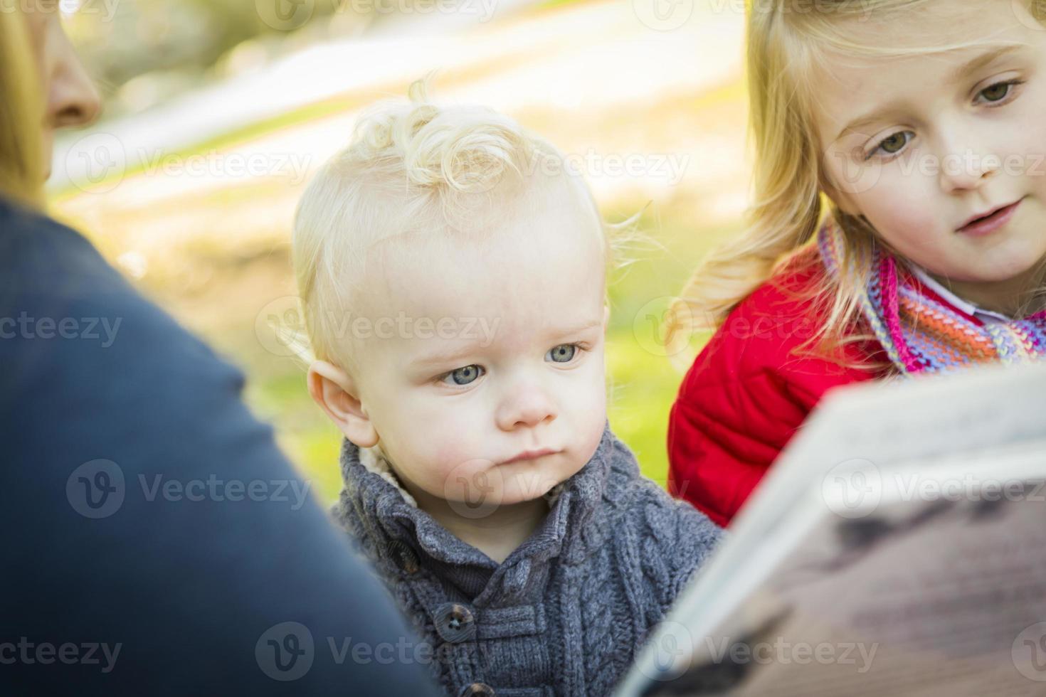 moeder lezing een boek naar haar twee aanbiddelijk blond kinderen foto