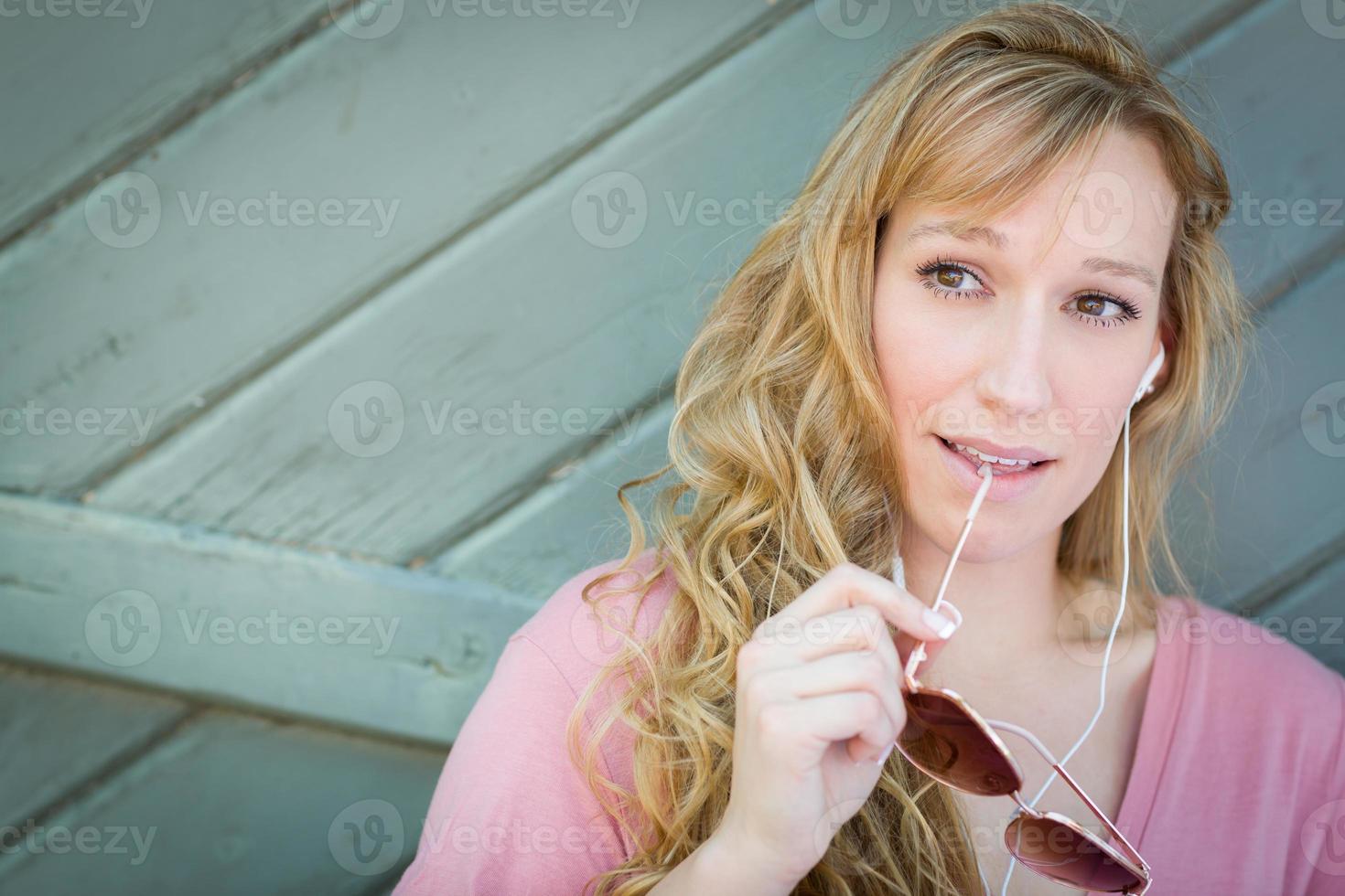 buitenshuis portret van jong volwassen bruin ogen vrouw met zonnebril en oortelefoons. foto