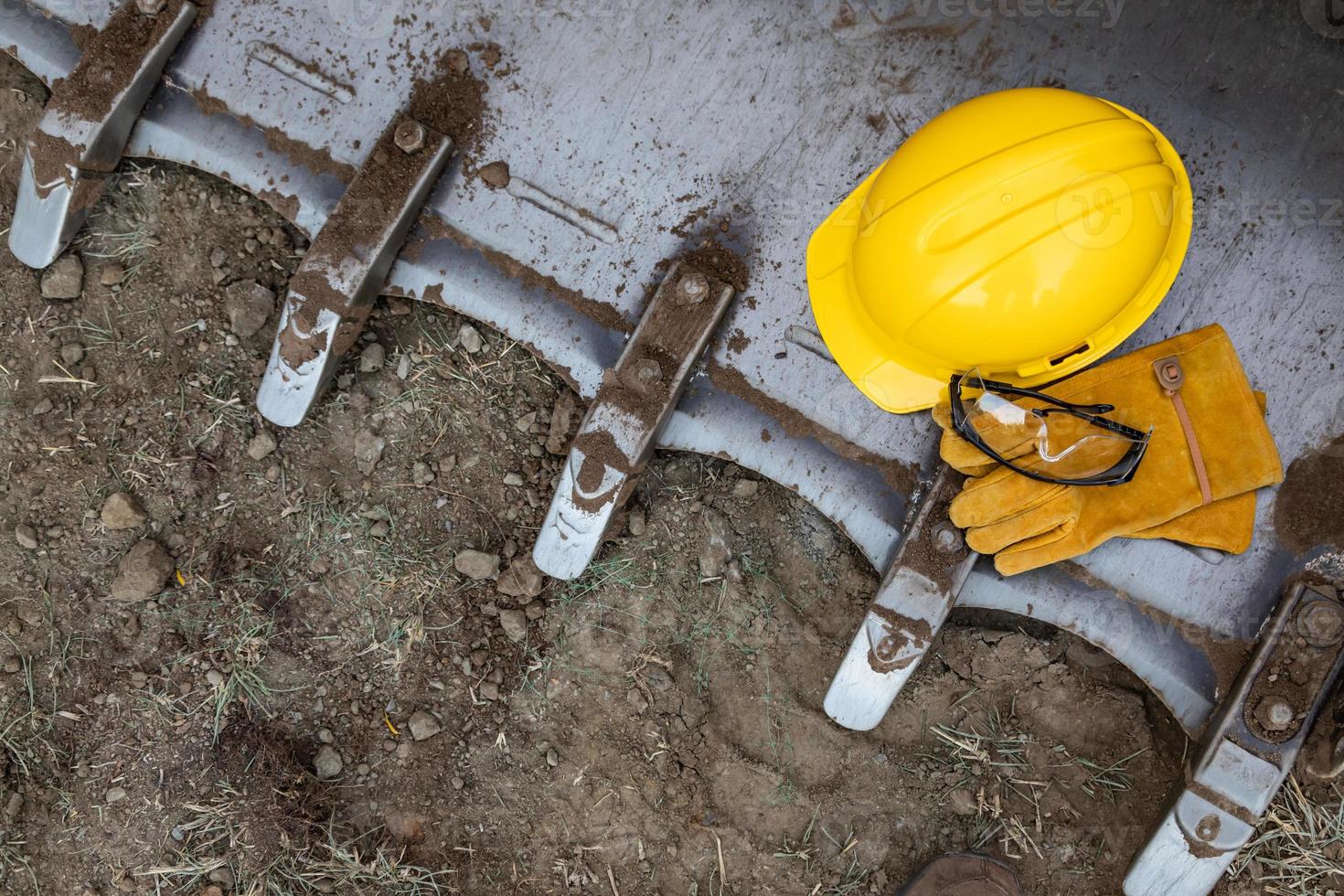 harde hoed, handschoenen en beschermend bril resting Aan bulldozer emmer abstract foto