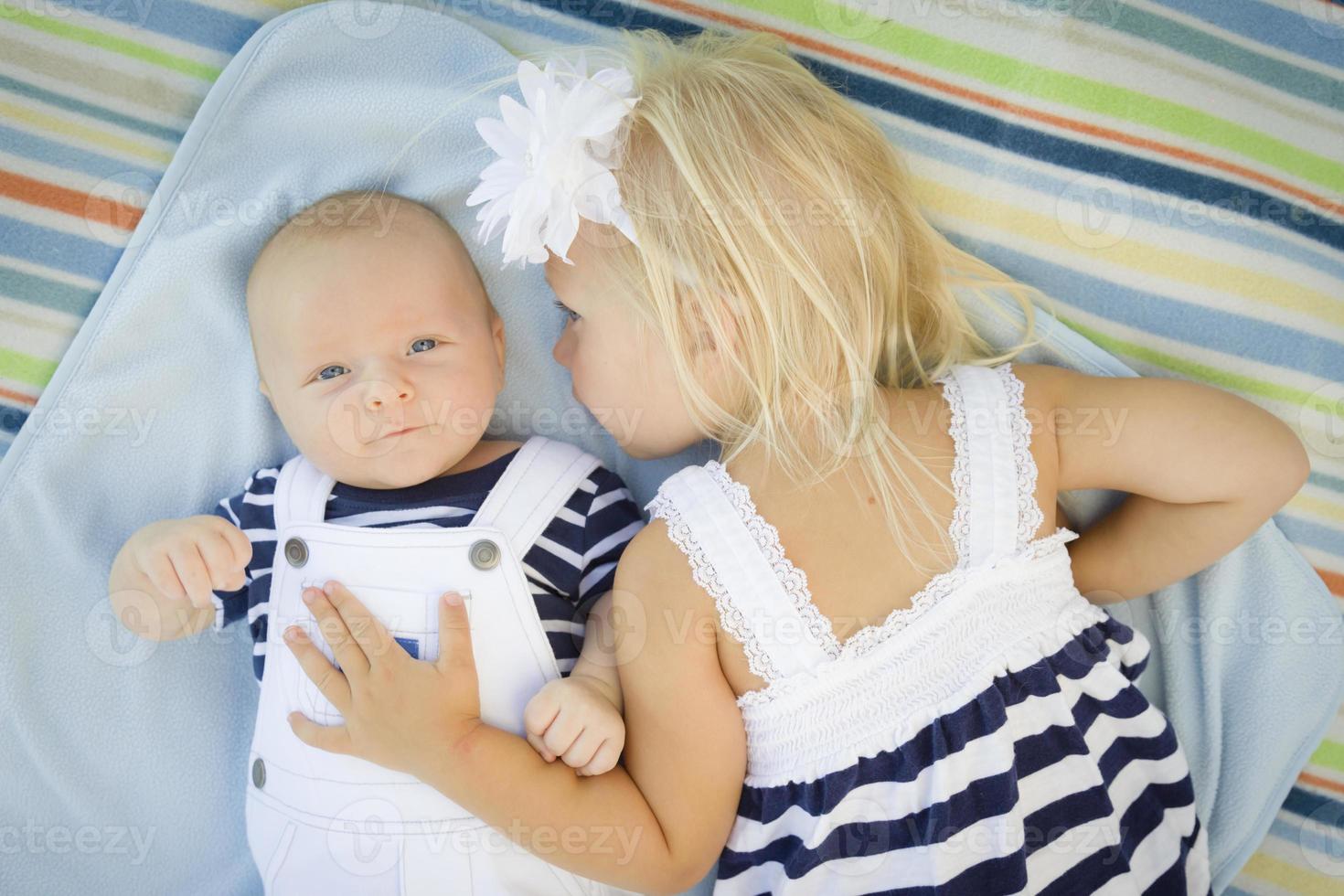 weinig zus houdende De volgende naar haar baby broer Aan deken foto