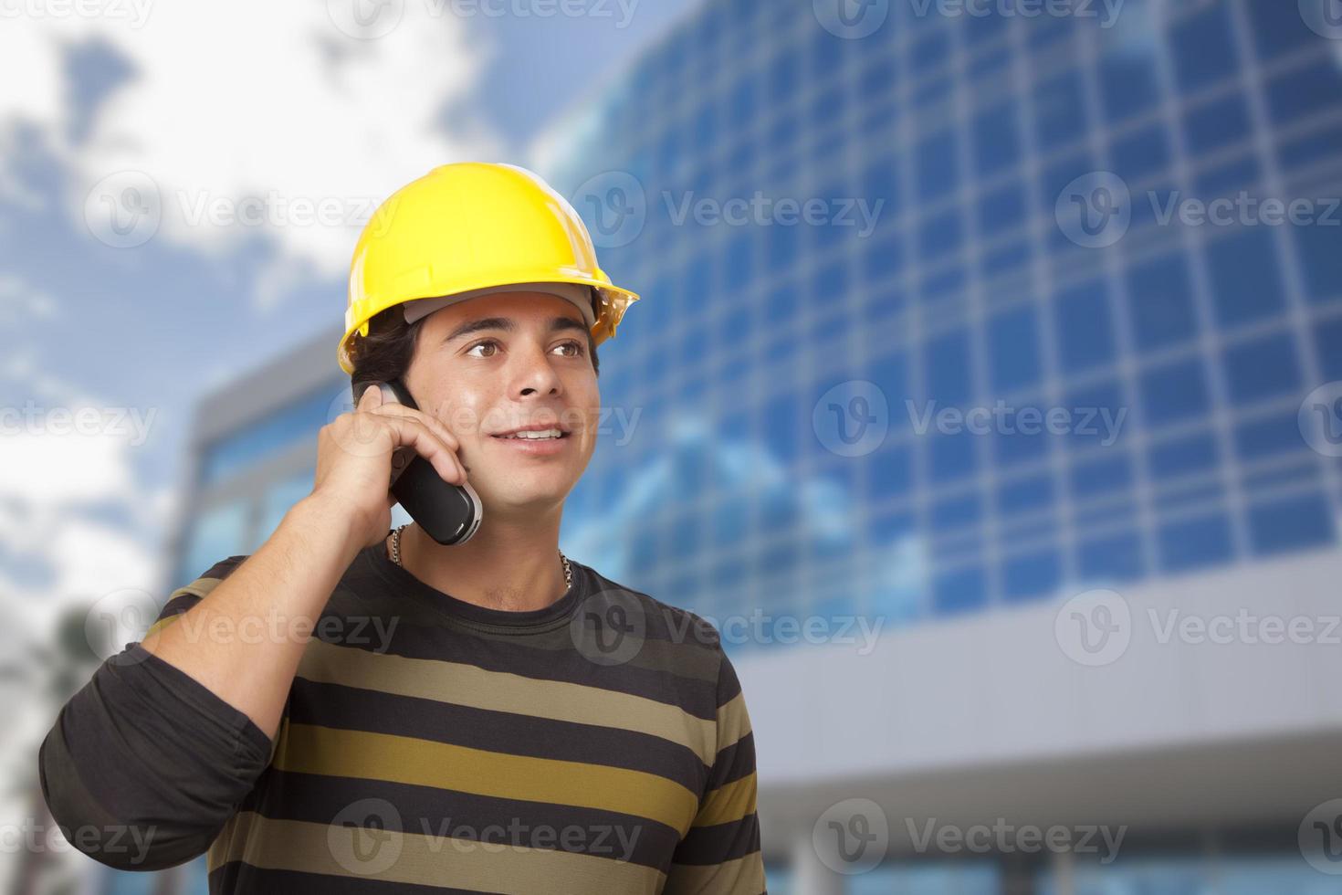 spaans mannetje aannemer Aan telefoon in voorkant van gebouw foto