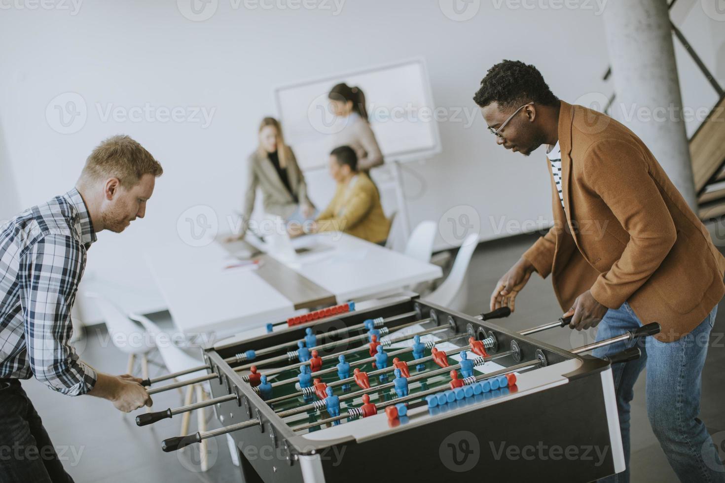 jong gewoontjes multi-etnisch bedrijf mensen spelen tafel Amerikaans voetbal en ontspannende Bij kantoor foto