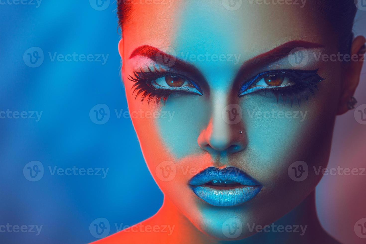 horizontaal portret van mooi meisje met maken omhoog in rood en blauw lichten foto