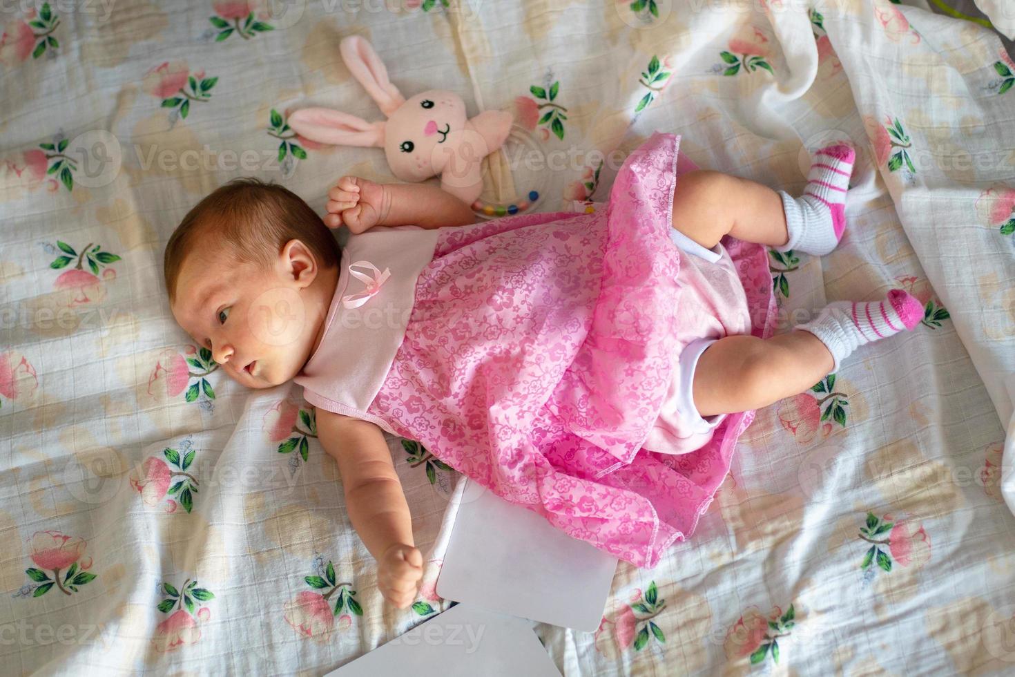 aanbiddelijk pasgeboren meisje in roze jurk foto