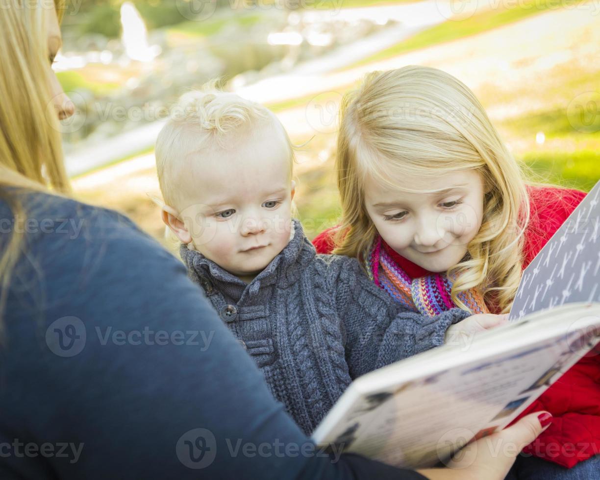 moeder lezing een boek naar haar twee aanbiddelijk blond kinderen foto