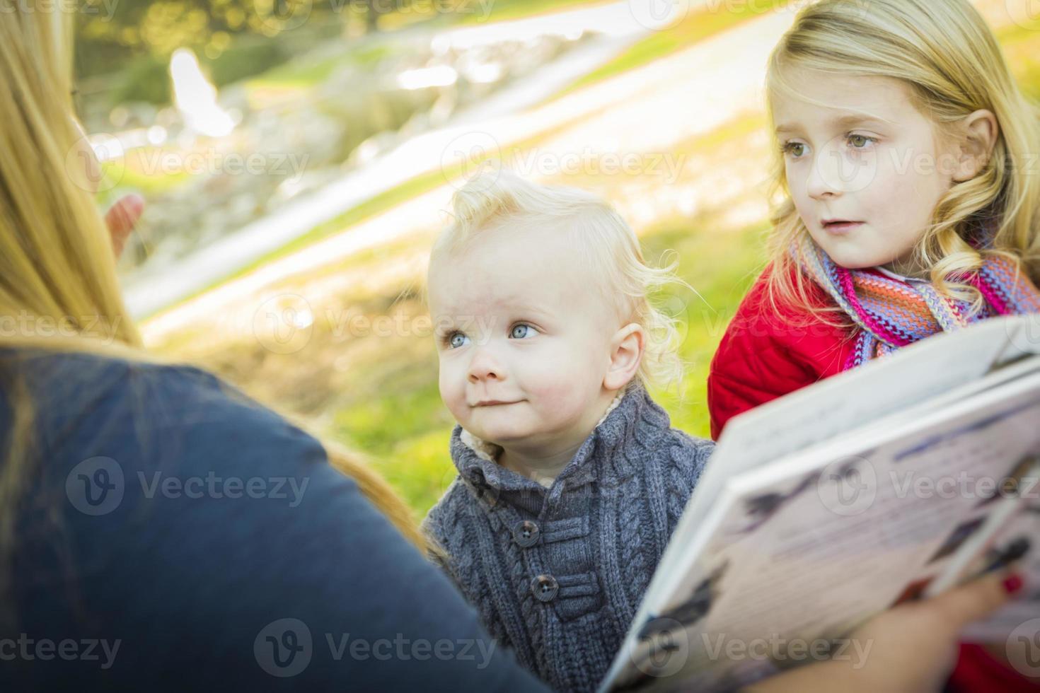 moeder lezing een boek naar haar twee aanbiddelijk blond kinderen foto