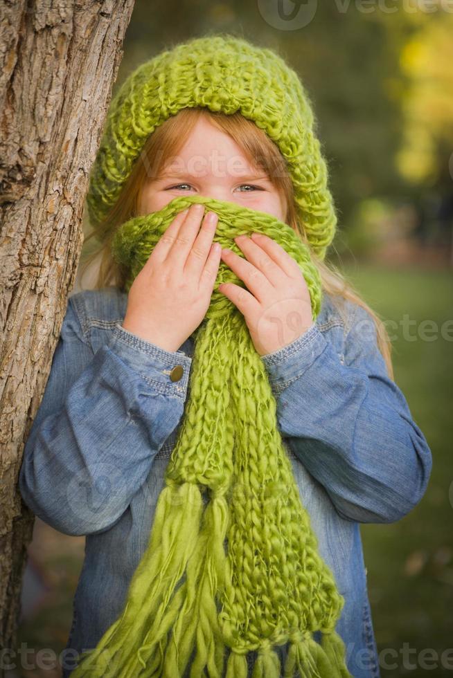 portret van schattig jong meisje vervelend groen sjaal en hoed foto