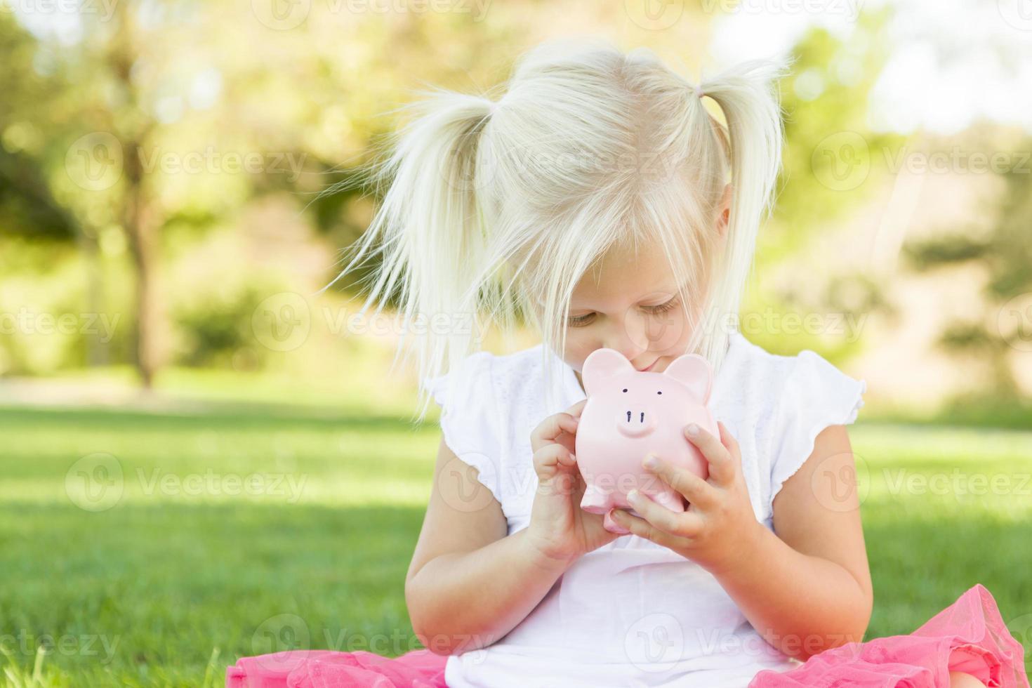 weinig meisje hebben pret met haar varkentje bank buiten foto