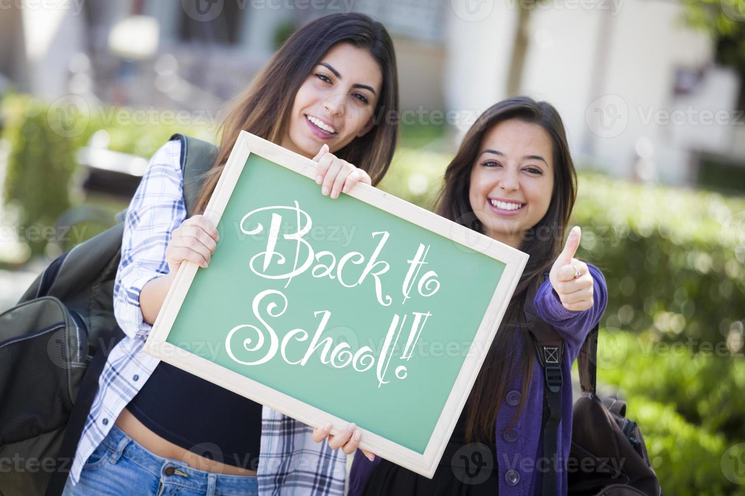 gemengd ras vrouw studenten Holding schoolbord met terug naar school- foto