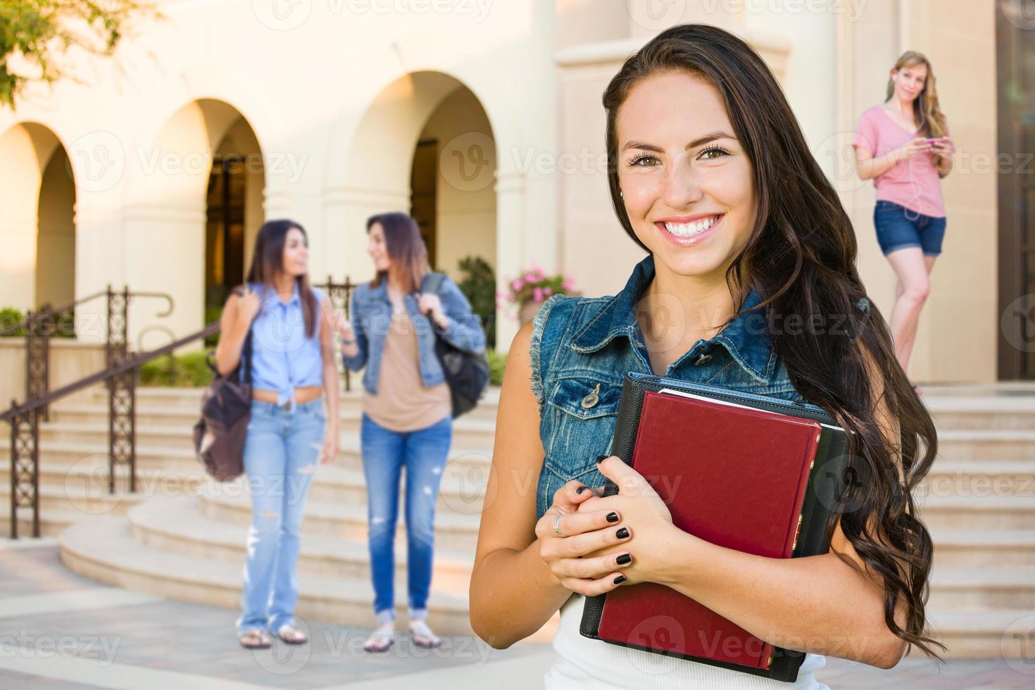 gemengd ras jong meisje leerling met school- boeken Aan campus foto