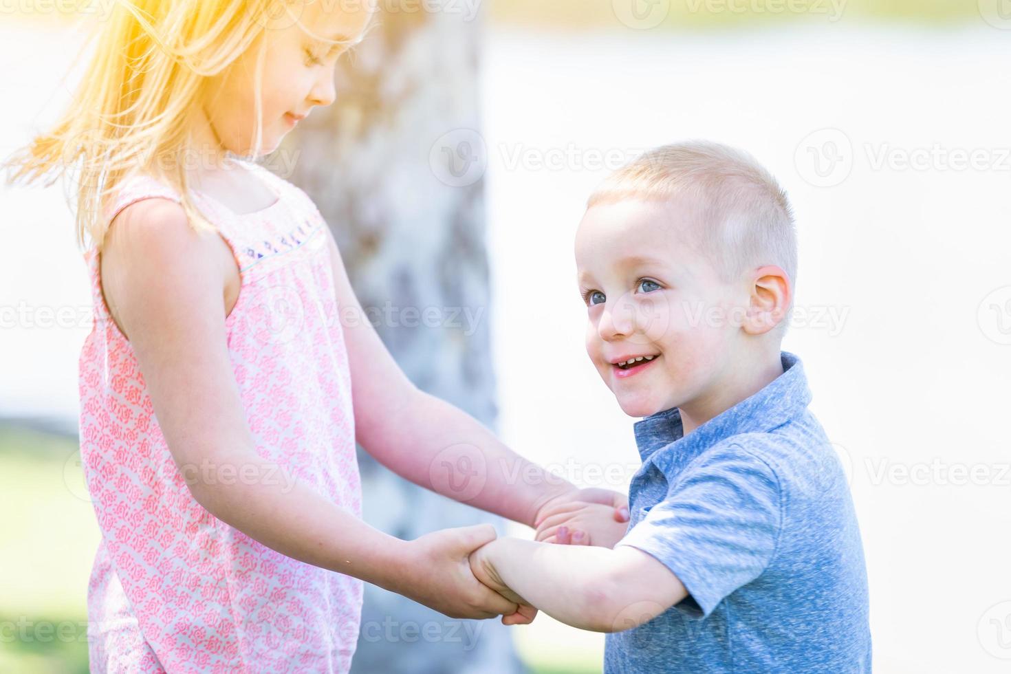 jong broer en zus spelen Bij de park samen foto