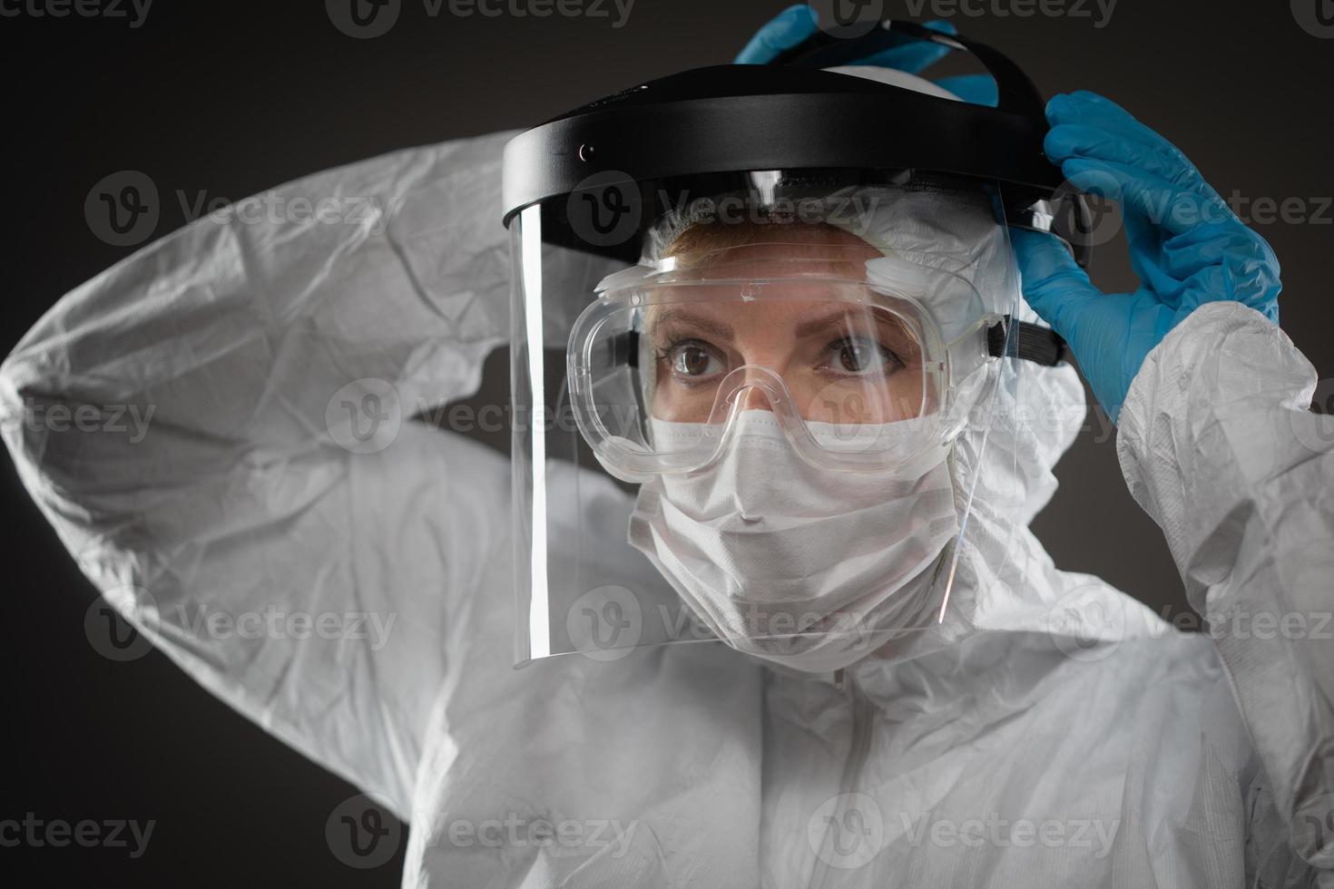 vrouw medisch arbeider vervelend beschermend gezicht masker en uitrusting tegen donker achtergrond foto