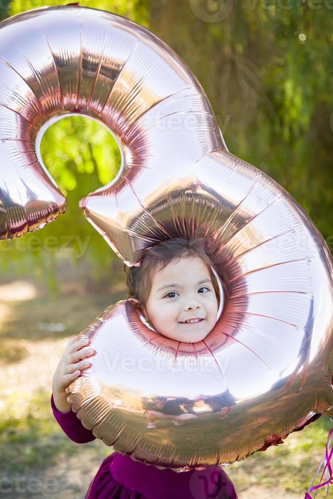 schattig baby meisje spelen met aantal drie mylar ballon buitenshuis foto