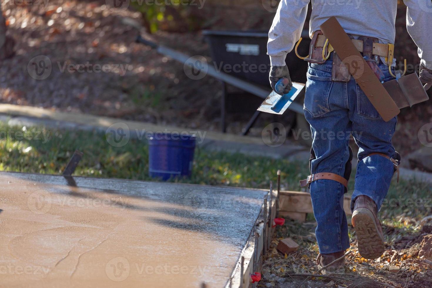 bouw arbeider met troffel gereedschap in de buurt nat dek cement foto