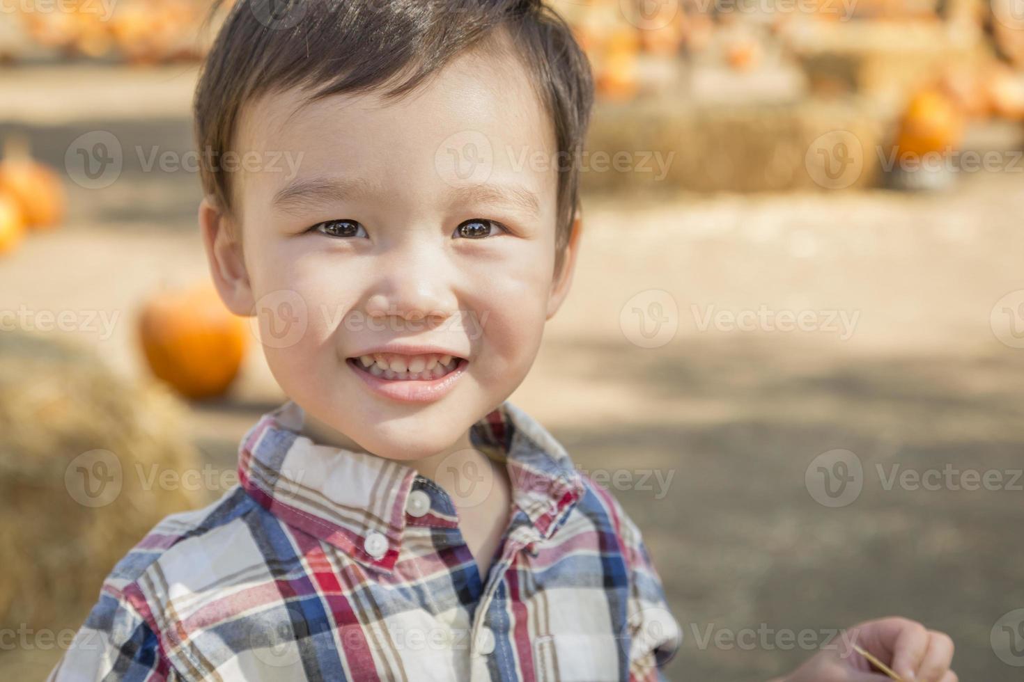 gemengd ras jong jongen hebben pret Bij de pompoen lap foto