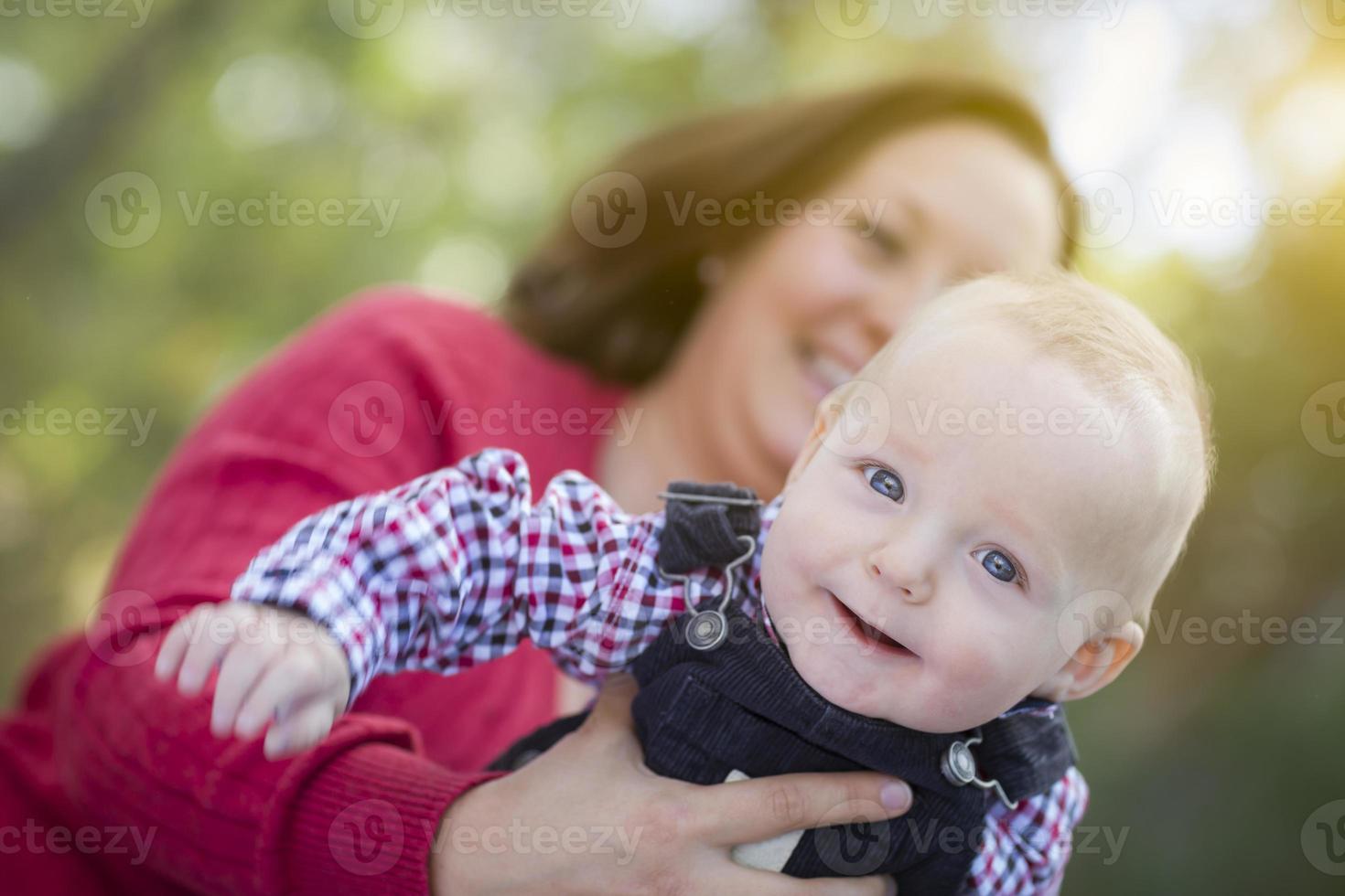 weinig baby jongen hebben pret met mama buitenshuis foto