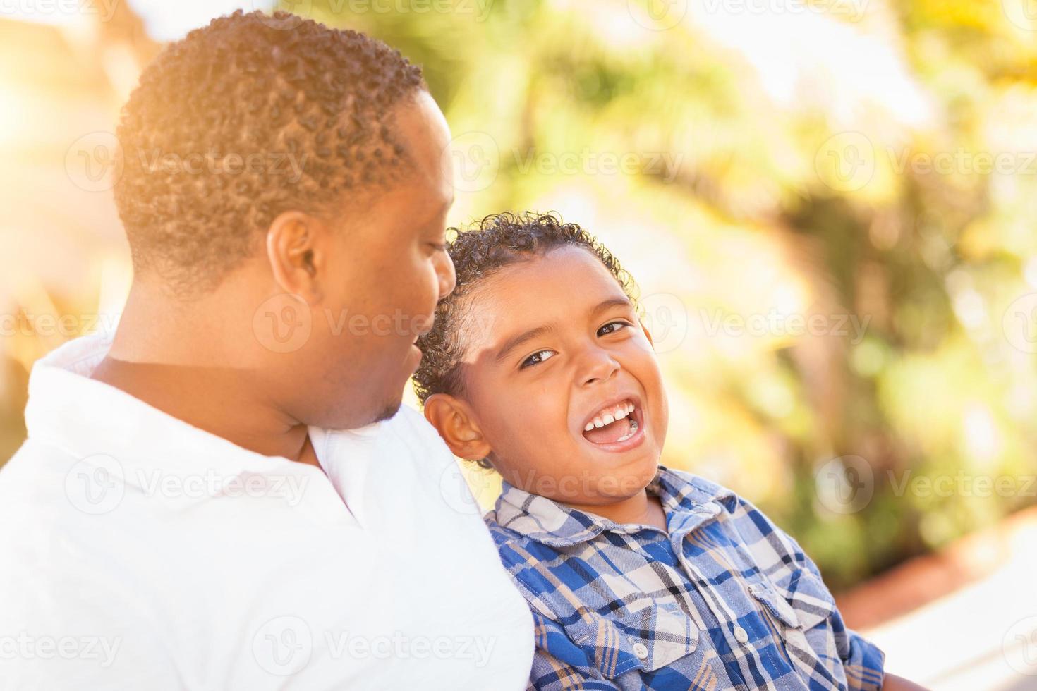 gemengd ras zoon en Afrikaanse Amerikaans vader spelen buitenshuis samen. foto