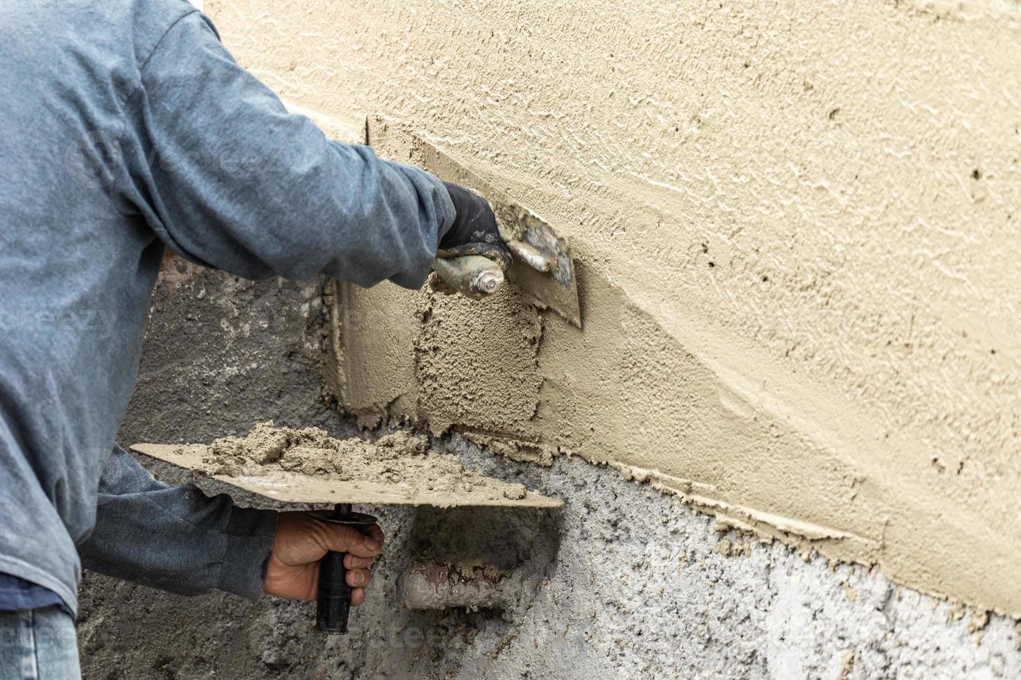 tegel arbeider toepassen cement met troffel Bij zwembad bouw plaats foto