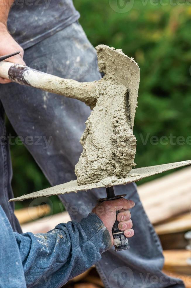 bouw arbeider plaatsen nat cement Aan schotel voor tegel arbeider Bij zwembad bouw plaats foto