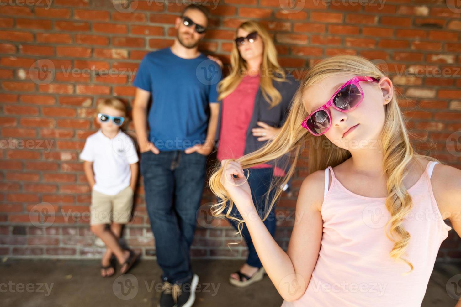 schattig jong Kaukasisch meisje vervelend zonnebril met familie achter foto