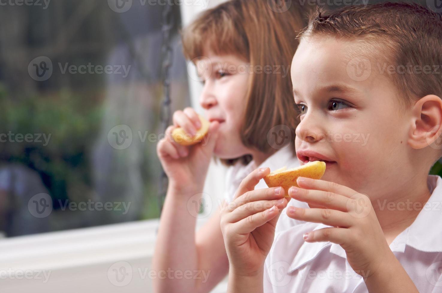 zus en broer aan het eten een appel foto