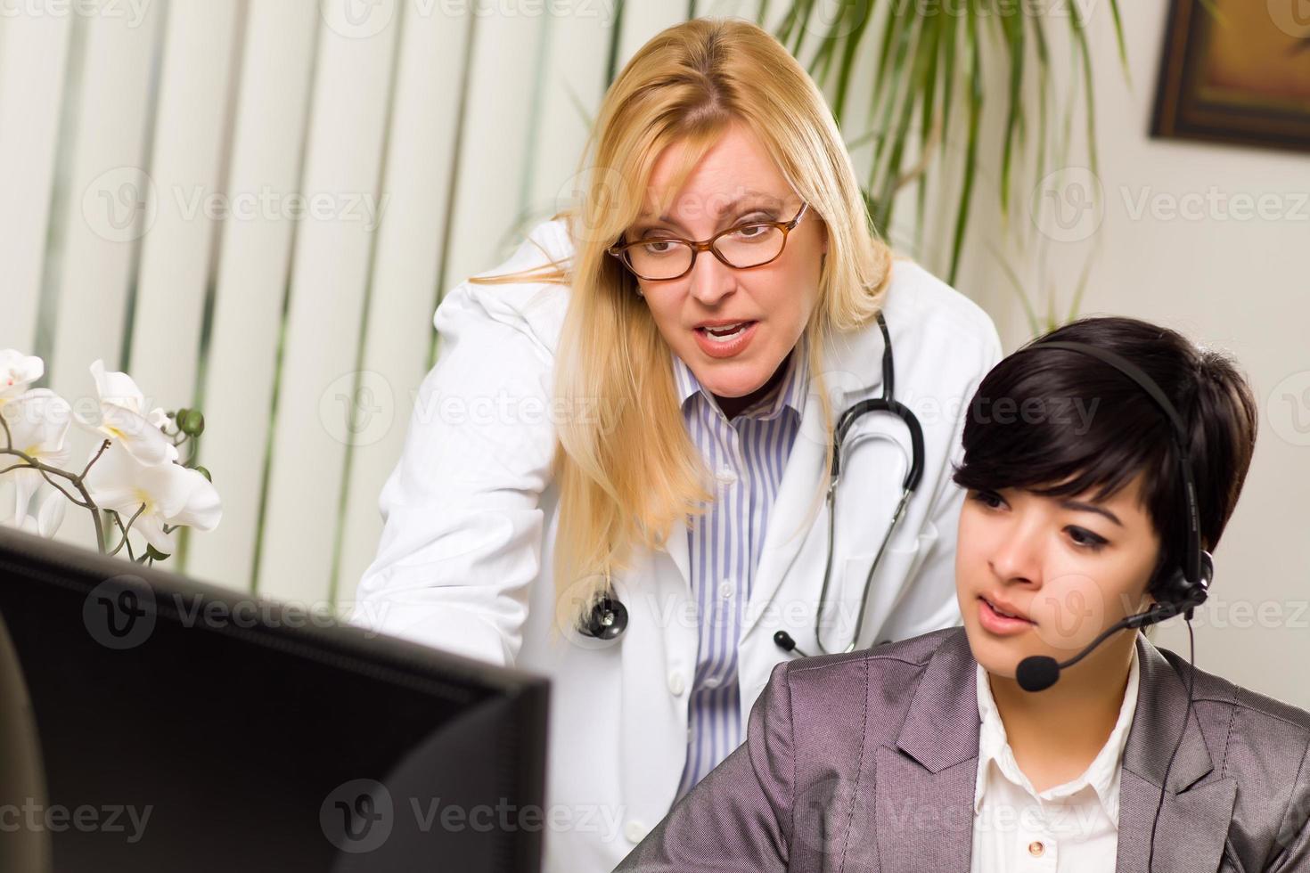 vrouw dokter bespreekt werk Aan computer met receptioniste assistent foto