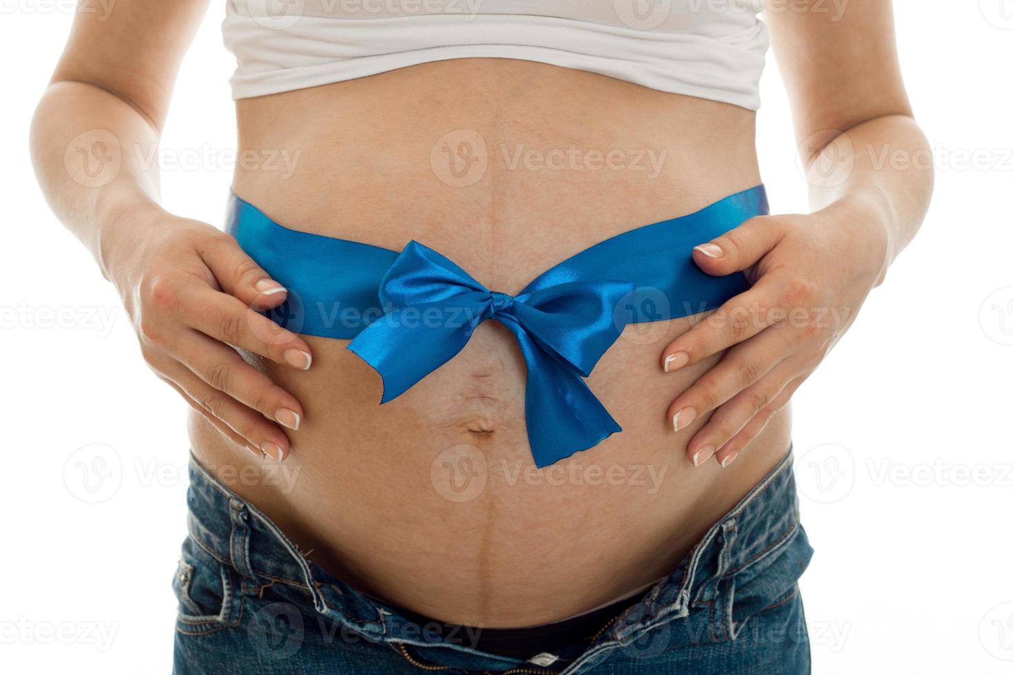 studio portret van zwanger vrouw met blauw plakband Aan haar buik geïsoleerd Aan wit achtergrond foto