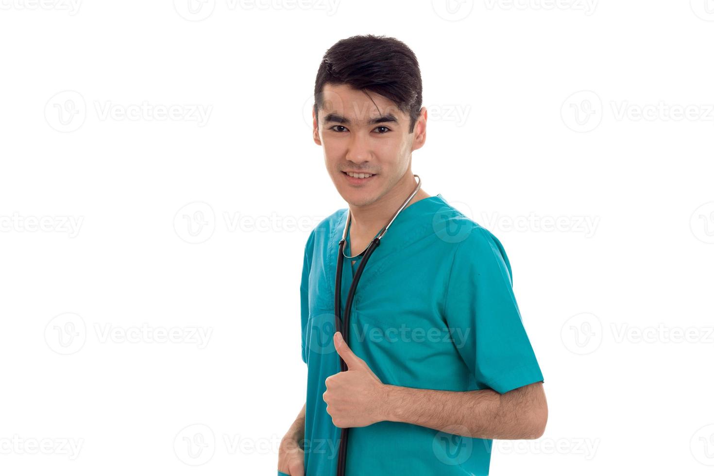 studio portret van brunette mannetje dokter in uniform poseren geïsoleerd Aan wit achtergrond foto