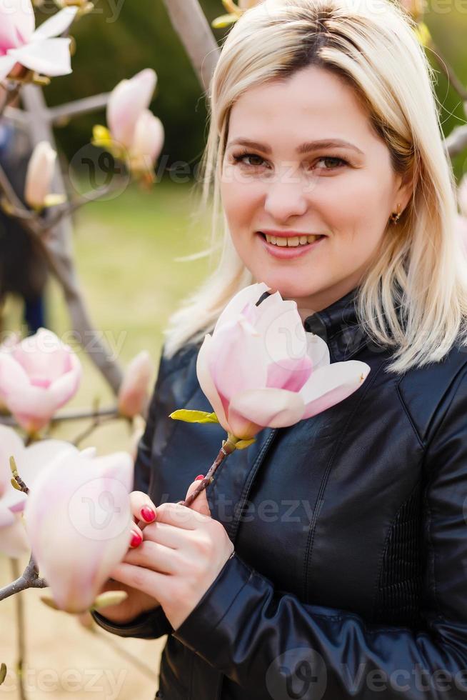 vrouw in voorkant van sakura voorjaar bloesems foto
