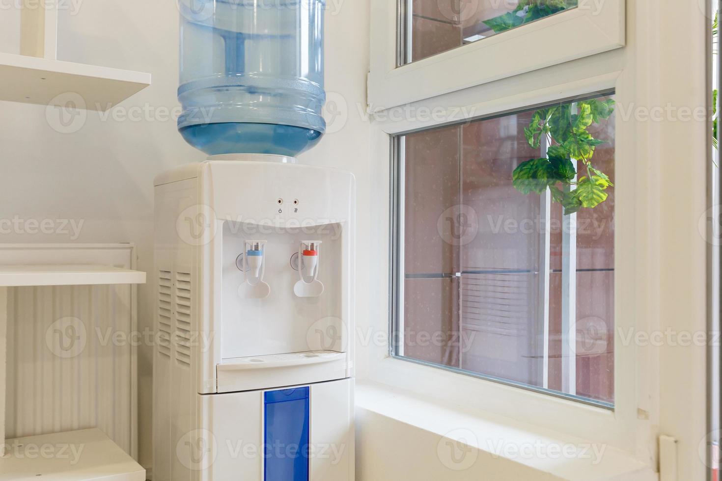 blauw water gallon Aan elektrisch water koeler in kantoor Oppervlakte foto