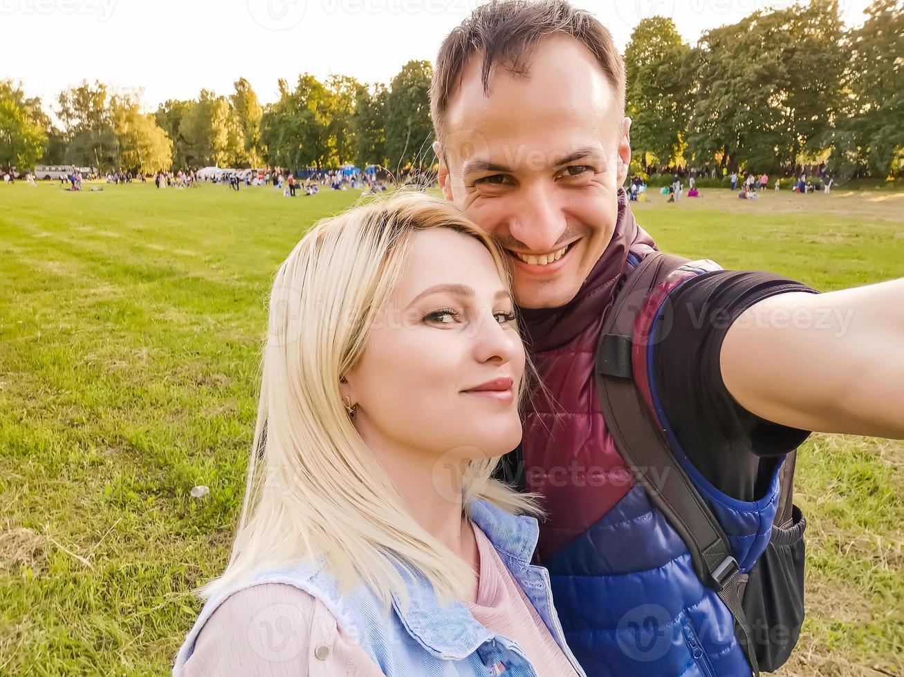 detailopname schot van jong paar nemen selfie buitenshuis. jong Mens nemen een foto met zijn vriendin. happpy glimlachen paar nemen een selfie in een zomer dag