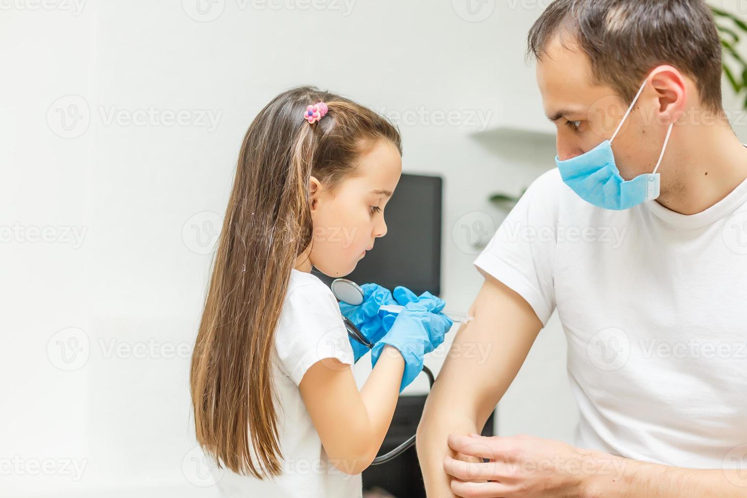 aanbiddelijk weinig meisje en haar vader of dokter in medisch masker door de venster Bij huis of ziekenhuis. . quarantaine. coronavirus. epidemie. foto