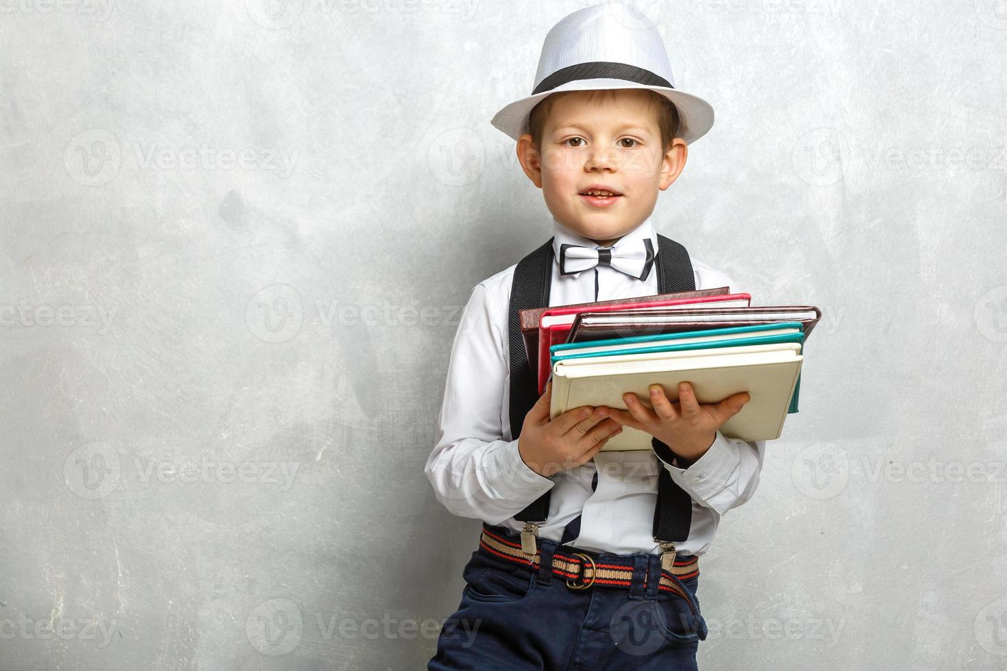 elementair school- leerling draag- notebooks over- een grijs achtergrond foto