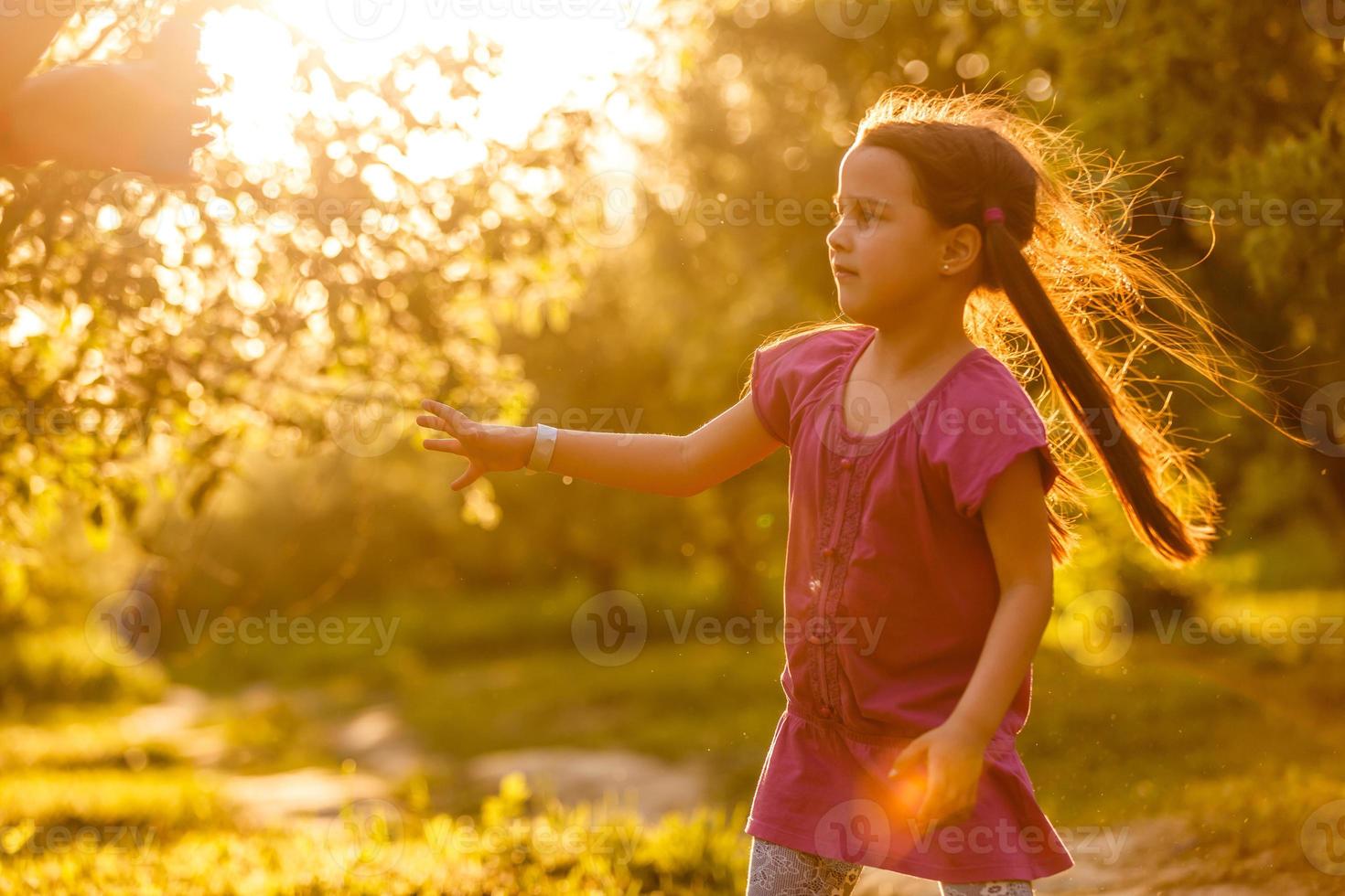 vijf jaren oud Kaukasisch kind meisje blazen zeep bubbels buitenshuis Bij zonsondergang - gelukkig zorgeloos jeugd. foto