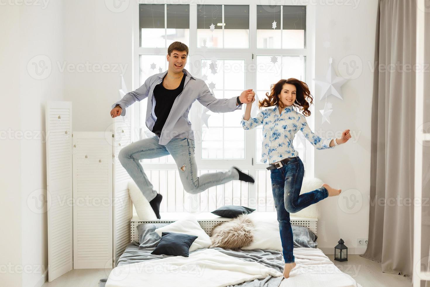 gelukkig liefhebbend paar jumping en hebben pret in bed foto