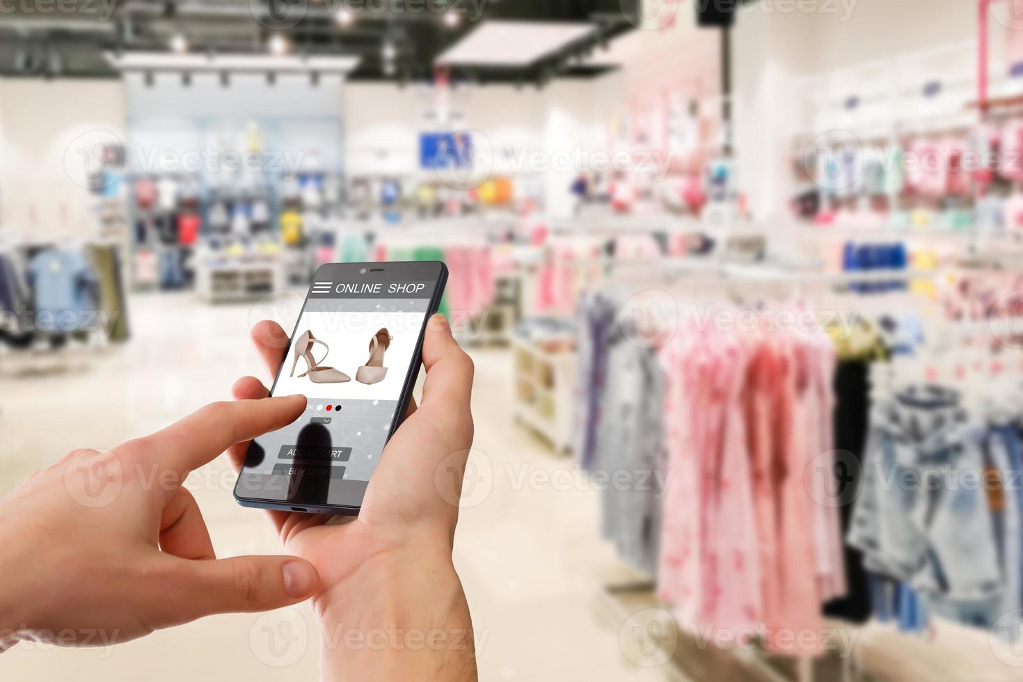 kleding op te slaan Holding telefoon in handen en zoeken online schoenen foto