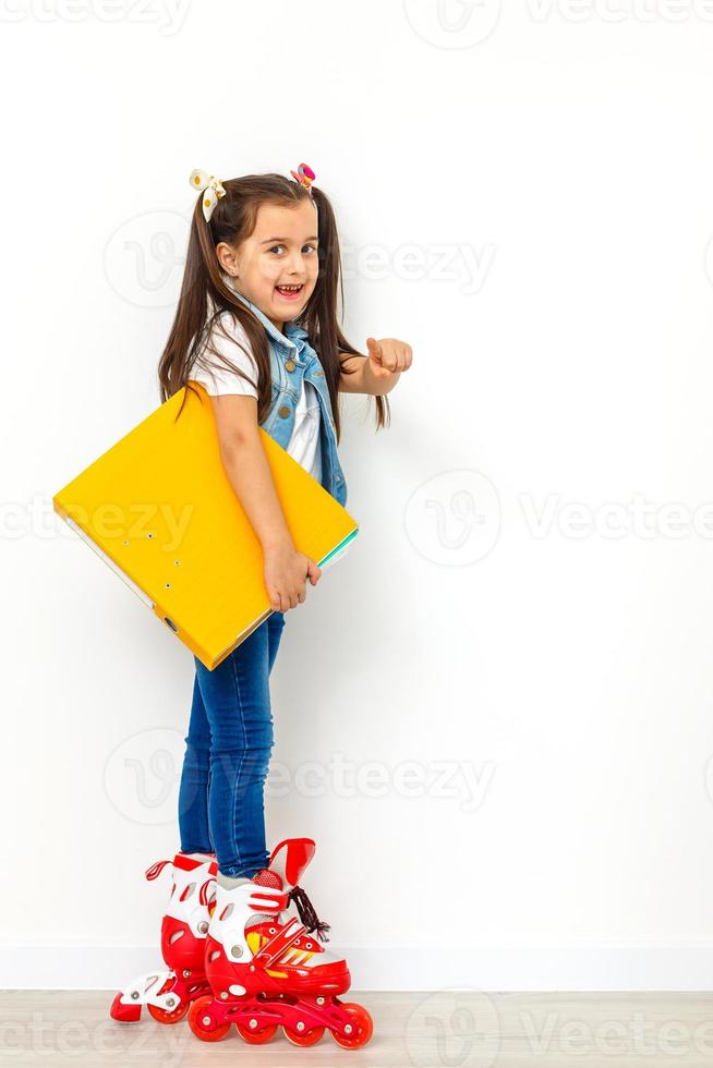 schattig meisje Aan rol skates tegen wit achtergrond foto