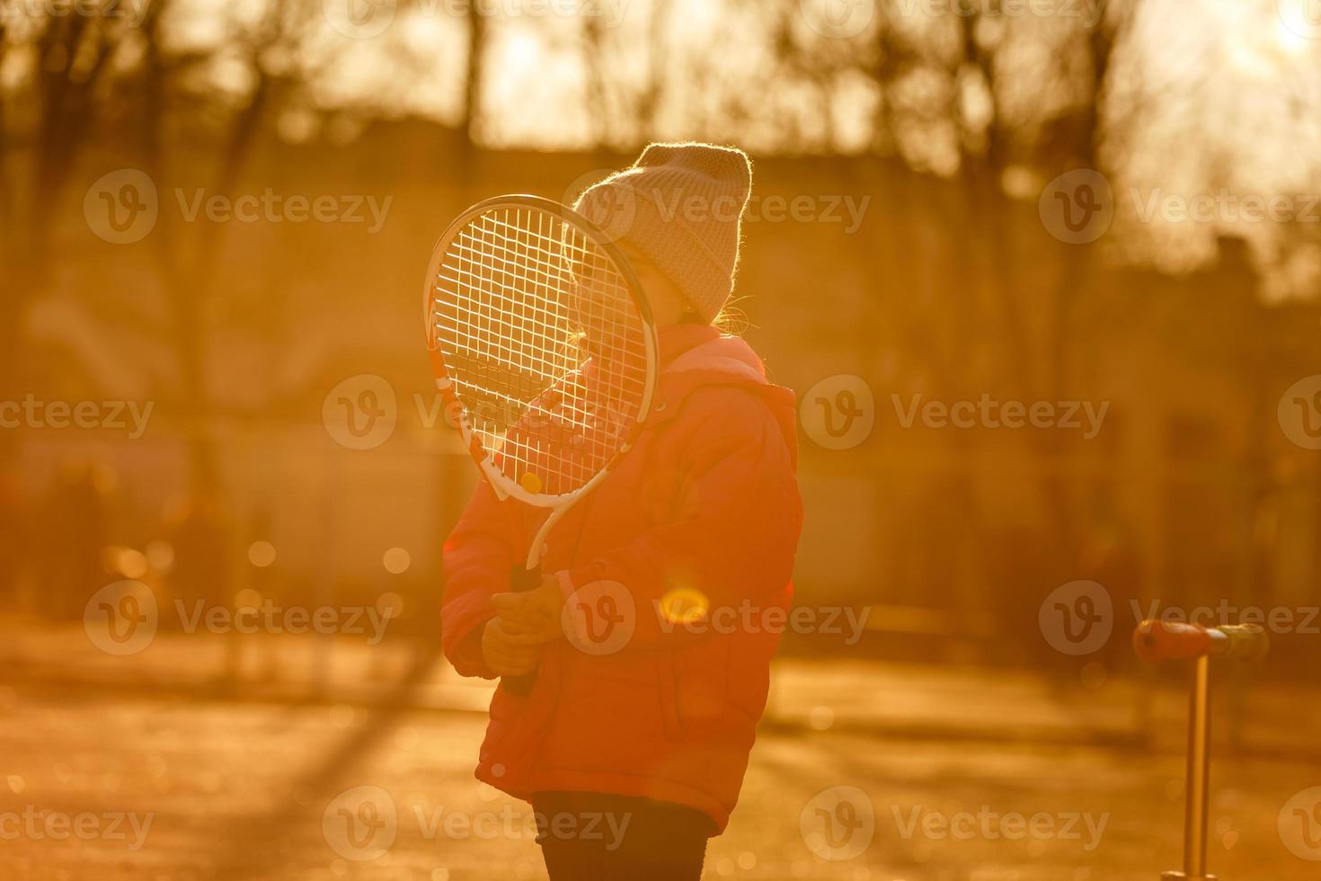 portret van een schattig weinig meisje spelen tennis. foto