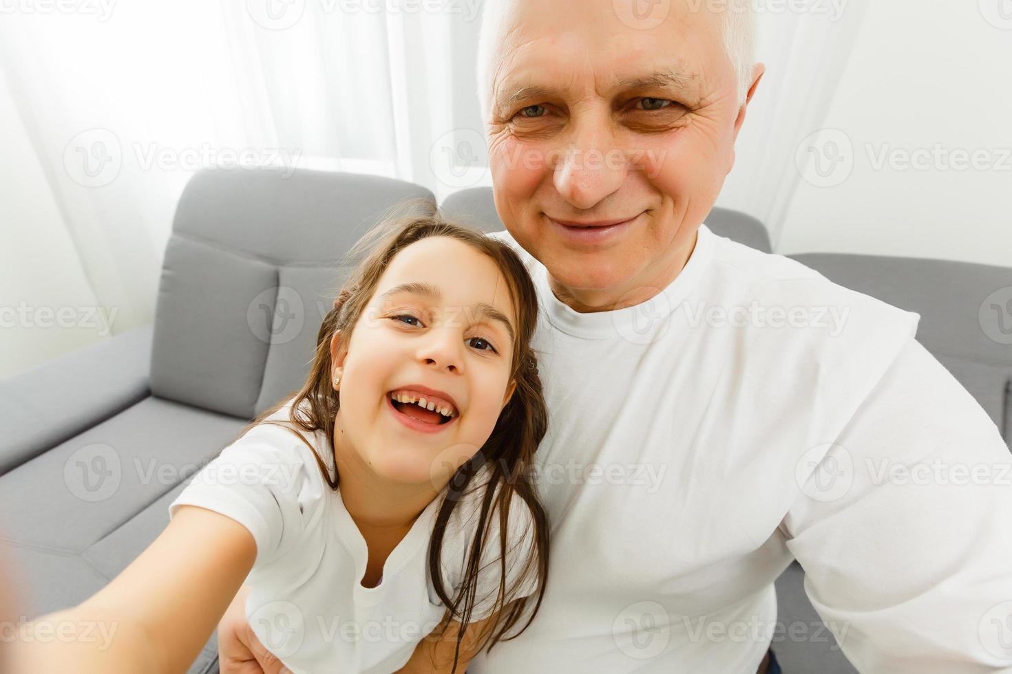 de gelukkig meisje en een opa maken een selfie foto